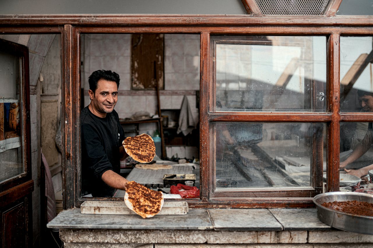 stats-img Man preparing traditional lahmacun in a rustic kitchen in Şanlıurfa, Turkey.
