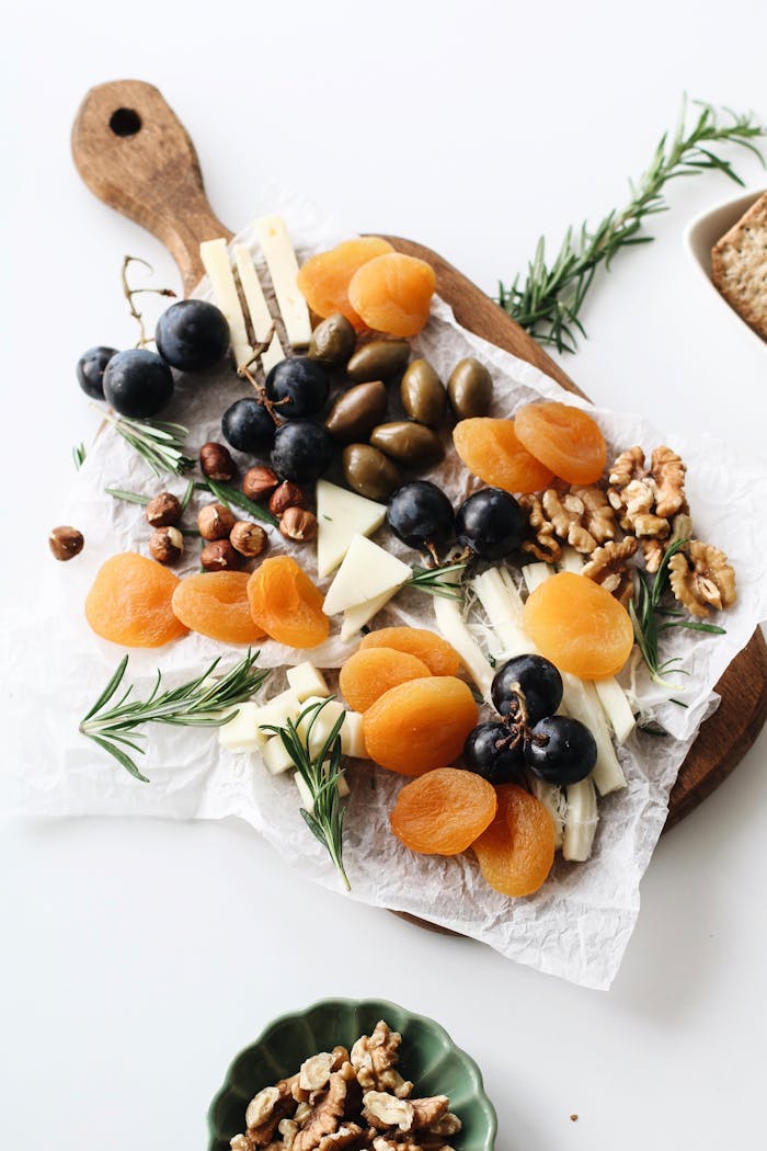 why-choose-us A rustic cheese platter with assorted nuts, dried fruits, and olives on a wooden board.